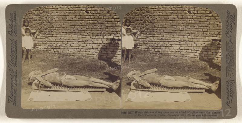 Hindu devotee doing penance on a bed of spikes near the shrine of Kali, Calcutta, India; Underwood & Underwood, American, 1881