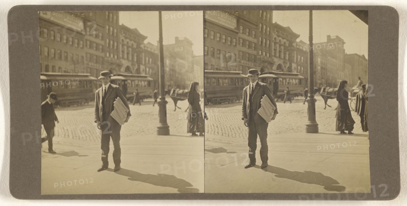 Man on street with stack of newspapers under his arm, Albany, N.Y; Julius M. Wendt, American, active 1900s - 1910s, 1900s