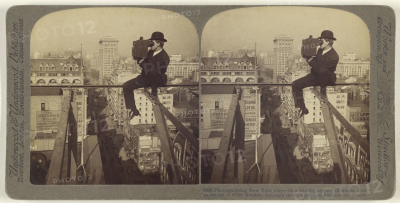 Photographing New York City - on a slender support 18 stories above pavement of Fifth Avenue; Underwood & Underwood, American