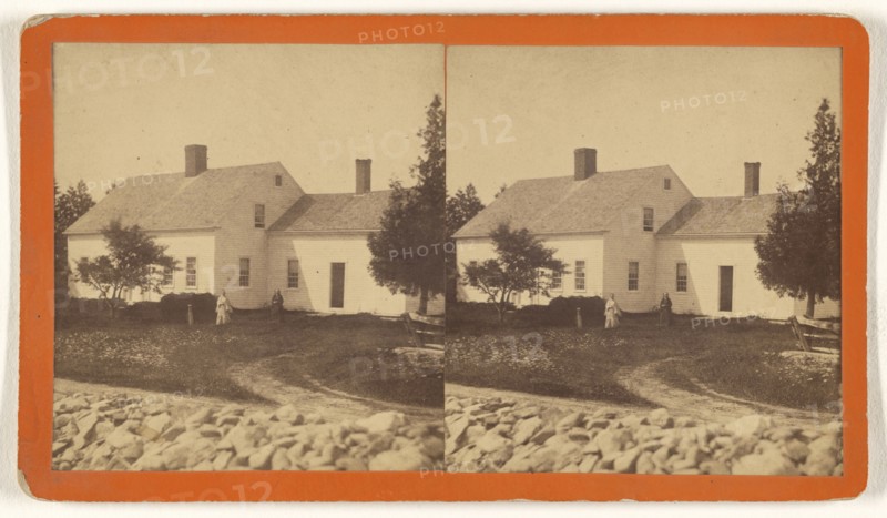 View of house with two women in the yard, white stone fence in foreground; about 1875; Albumen silver print