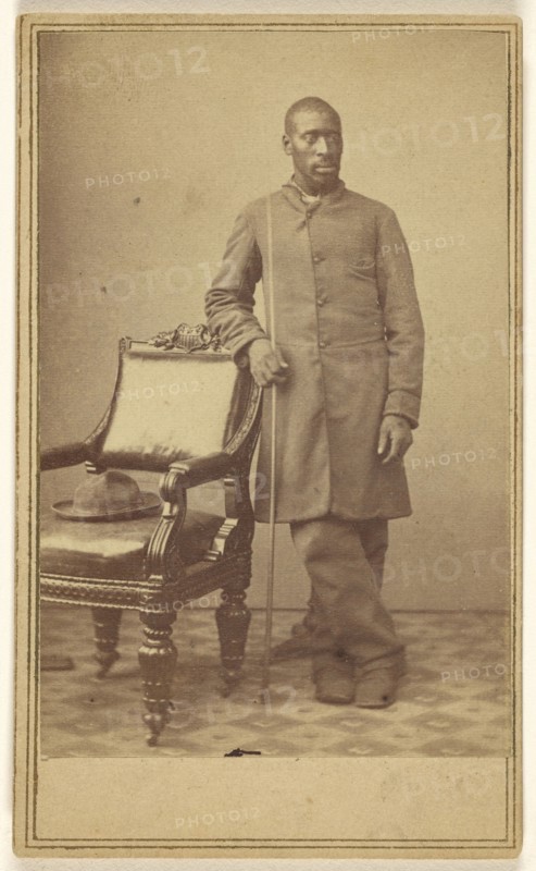 Black soldier standing near chair with hat in seat; Alexander Gardner, American, born Scotland, 1821 - 1882, about 1862