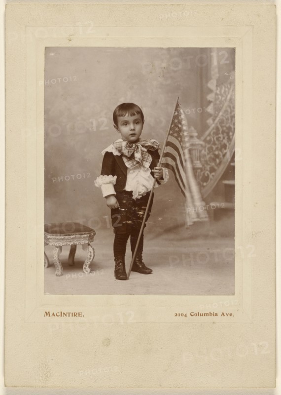 Little boy standing, holding an American flag; MacIntire, American, active 1890s, about 1890; Gelatin silver print