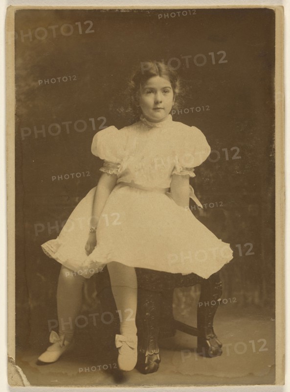 young girl in a white dress, seated; about 1920; Bromide print