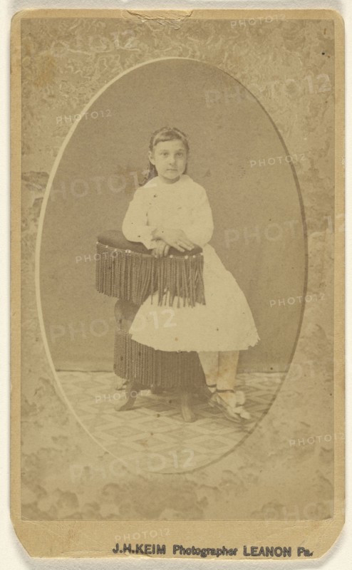 little girl posed on chair with tassels, printed in quasi-oval style; J.H. Keim, American, active 1920s, 1865 - 1870; Albumen