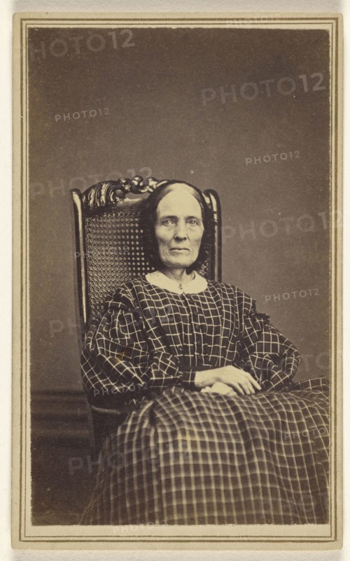 woman wearing a checkered dress, seated in a wicker chair; Abraham F. Burnham, American, active 1880s - 1890s, 1866; Albumen