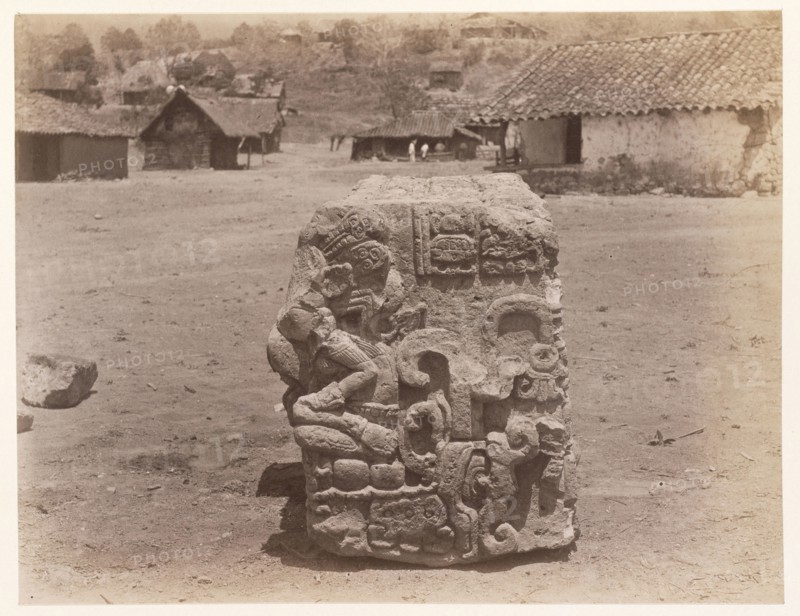 Carved block, with village buildings in background, Edmund Lincoln miscellaneous papers relating to the excavation of Maya ruins