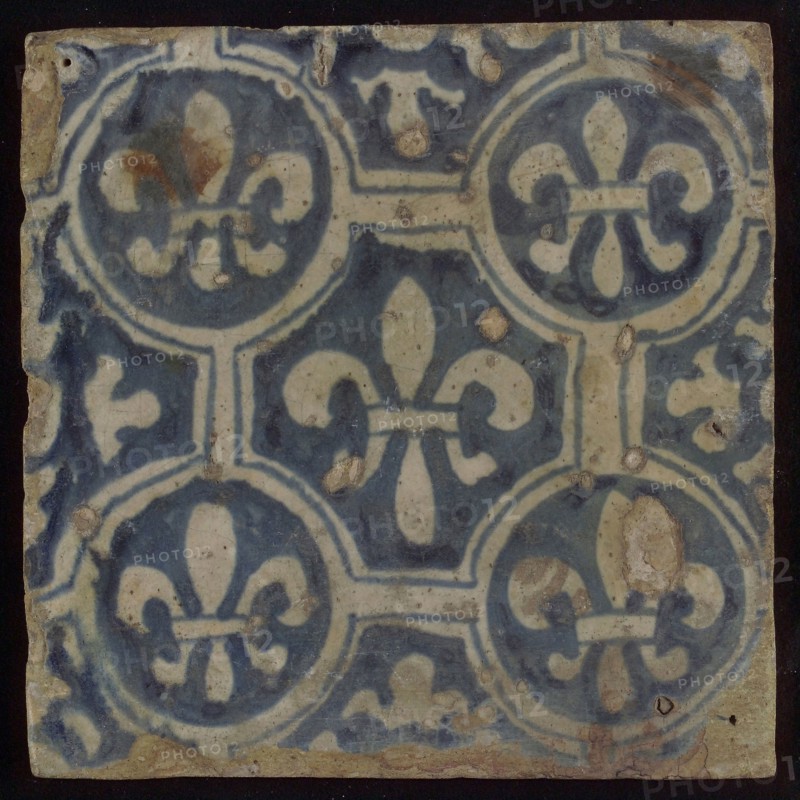 Two-tone tile, blue on white background, four circles with white French lily around central ornament with lily, wall tile