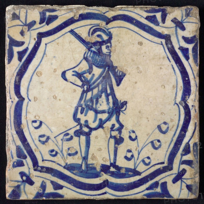 White tile with blue warrior in accolade-shaped frame; corner motif wing leaf, wall tile tile sculpture ceramic earthenware