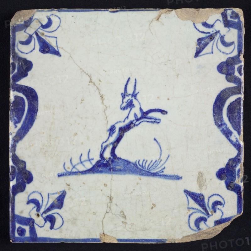 Animal tile, jumping buck to the right on ground between balusters, in blue on white, corner pattern french lily, wall tile