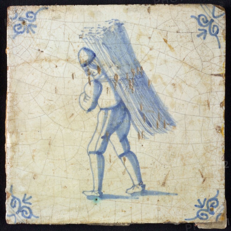 Occupation tile, blue, depicting man with bunch of straw on his back, corner motif, ox's head, wall tile tile sculpture ceramic
