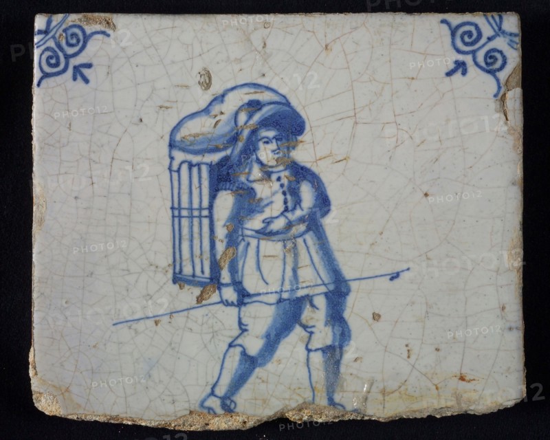 Occupation tile, blue with man with hat and basket on the back, bag carrier, corner motif oxen head, wall tile tile sculpture