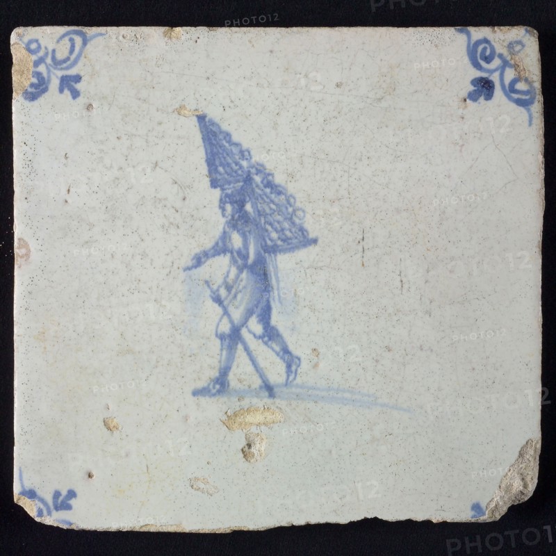 Occupation tile, blue with man with rack of firewood On the back, corner motif oxen head, wall tile tile sculpture ceramic