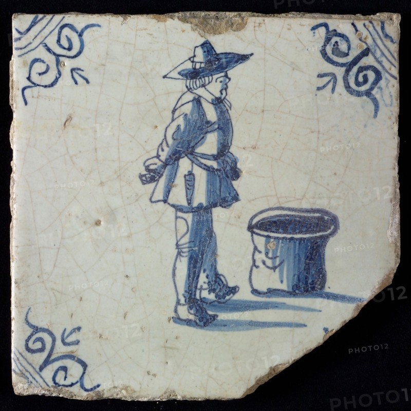 Occupation tile, blue with warrior standing by barrel, corner motif oxen head, wall tile tile sculpture ceramic earthenware
