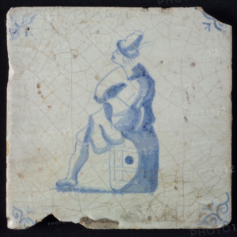 Occupation tile, blue with man sitting on barrel, corner motif ox's head, wall tile tile sculpture ceramic earthenware glaze