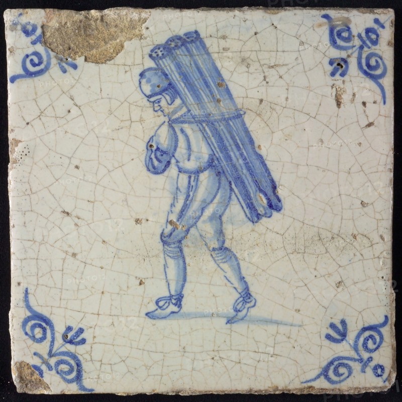 Occupation tile, blue with man carrying with beams or tubes, corner motif ox's head, wall tile tile sculpture ceramic