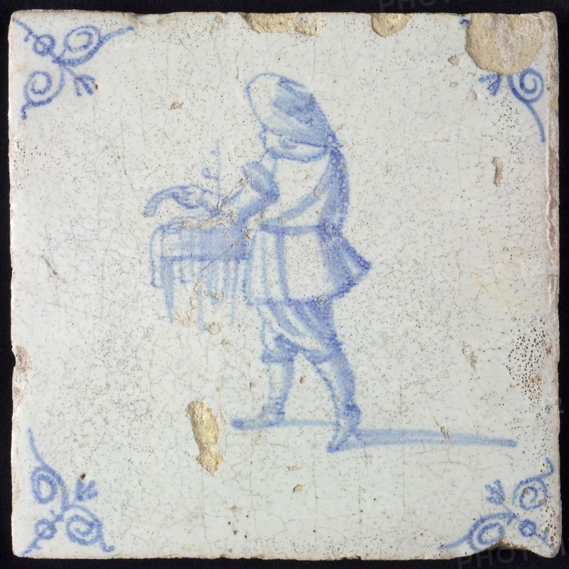 Tile with hawker with bowl with pipes in the hands, corner motif of ox's head, wall tile tile sculpture ceramic earthenware