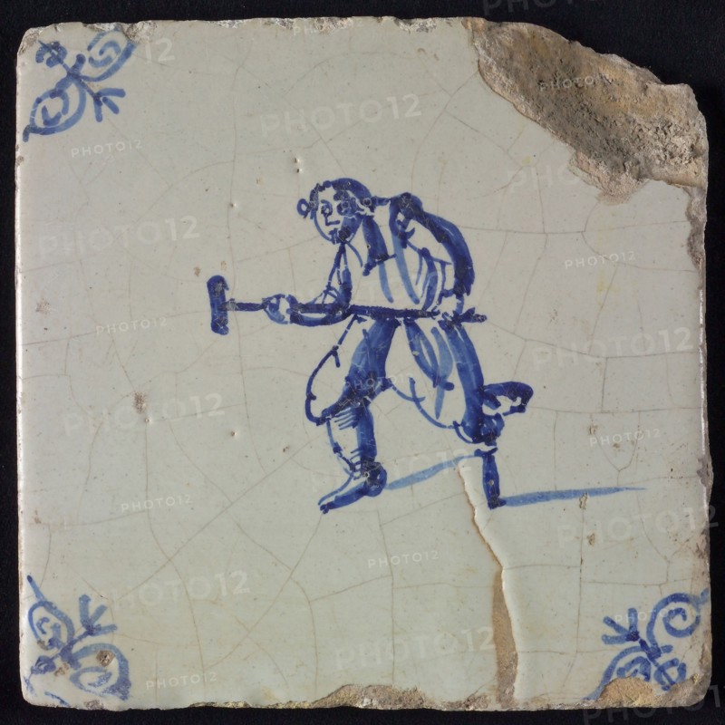 Figure tile, blue with man with wooden leg and stool, in attacking position, corner pattern ox head, wall tile tile sculpture