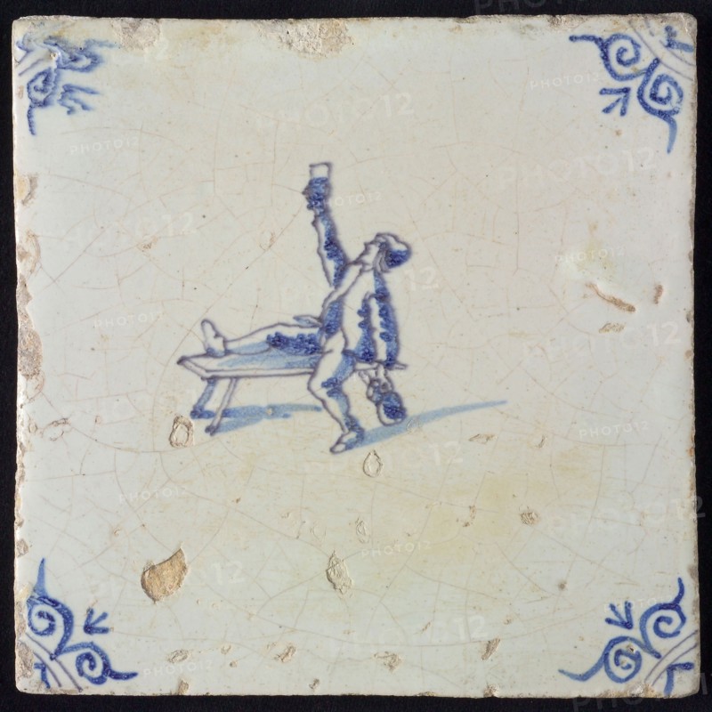 Figure tile, blue with man sitting with one leg on bench, lifting glass, another hand beer jug, corner motif oxen head, wall
