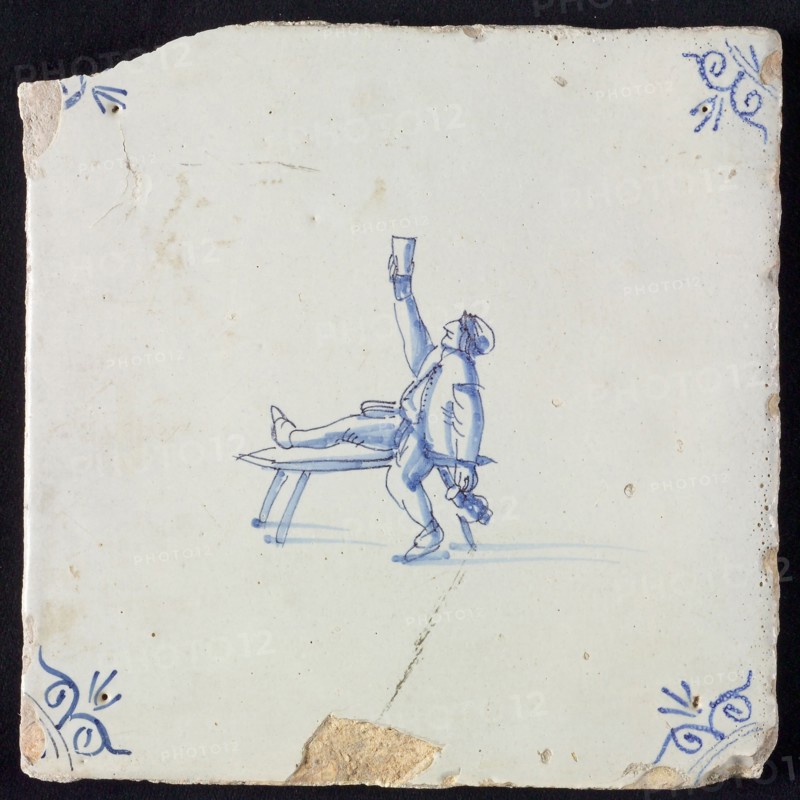 Figure tile, blue with man sitting with one leg on bench, lifting glass, another hand beer jug, corner pattern ox-head, wall