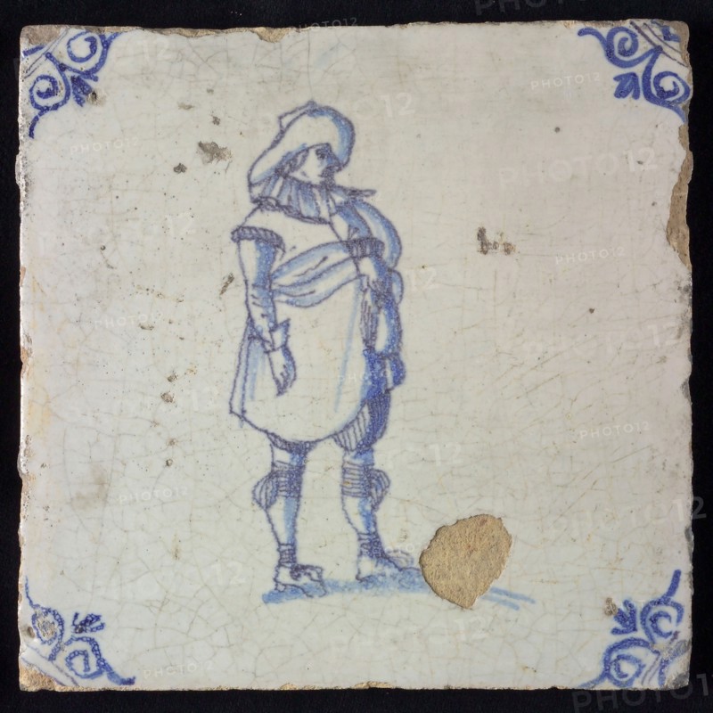Figure tile, blue with standing man with big hat, stands with big belly forward, corner pattern ox-head, wall tile