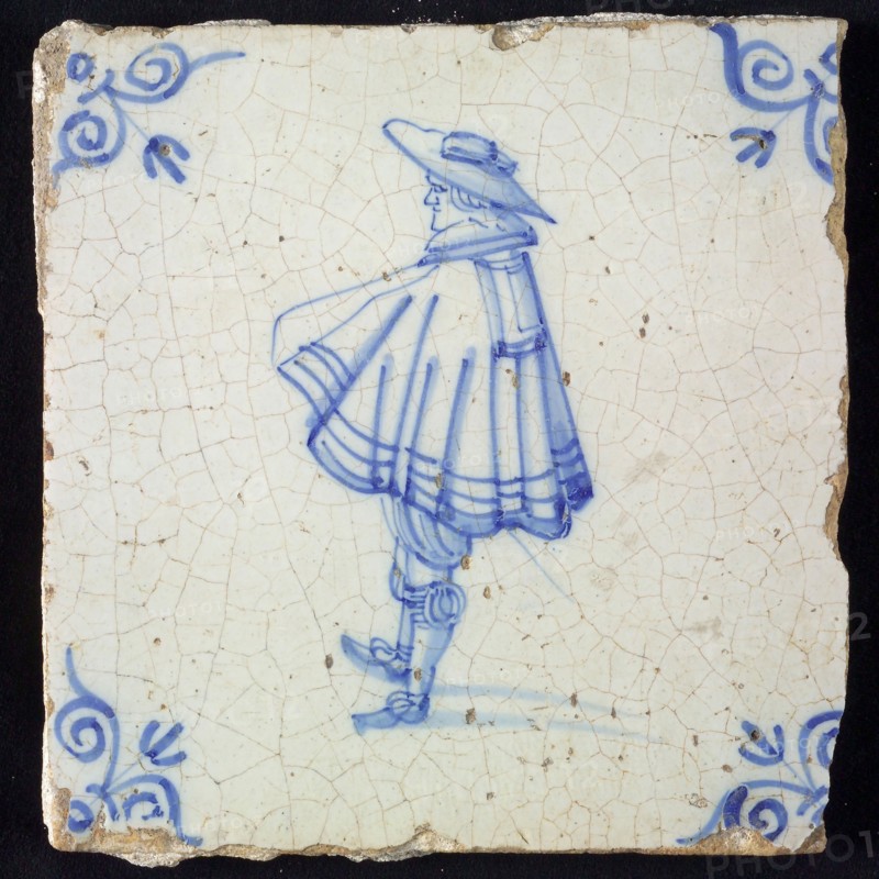 Figure tile, blue with nobleman with wide cape and big hat, corner pattern ox's head, wall tile tile sculpture ceramic