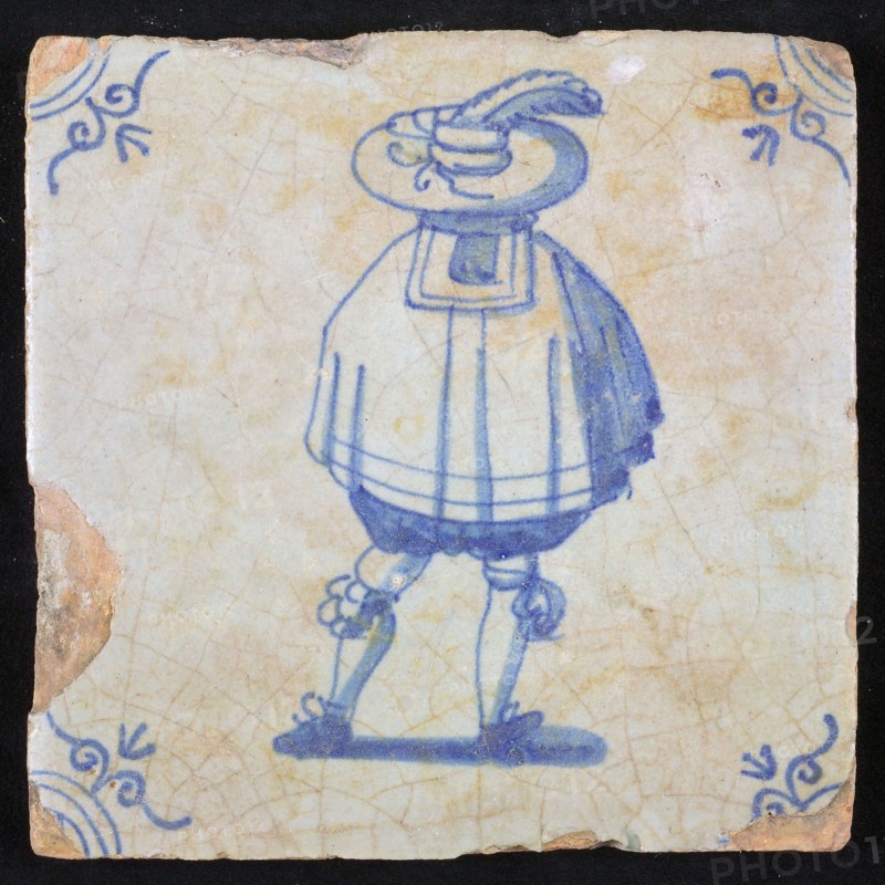 Figure tile, blue with nobleman seen on the back, wide cape and big hat with plume, corner pattern ox head, wall tile