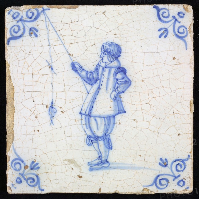 Figure tile, blue with man with fishing rod with fish, corner motif of ox's head, wall tile tile sculpture ceramic earthenware