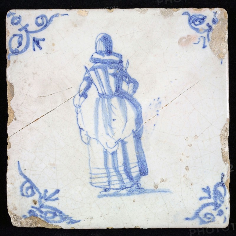 Figure tile, blue with lady with millstone collar and recorded overcoat, seen from the back, corner pattern ox's head, wall tile