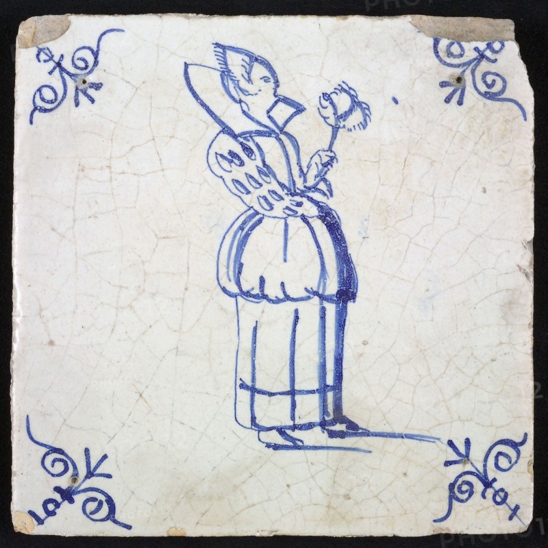 Figure tile, blue with distinguished lady with very high collar and wide sleeves and feather fan in hand, corner pattern ox head