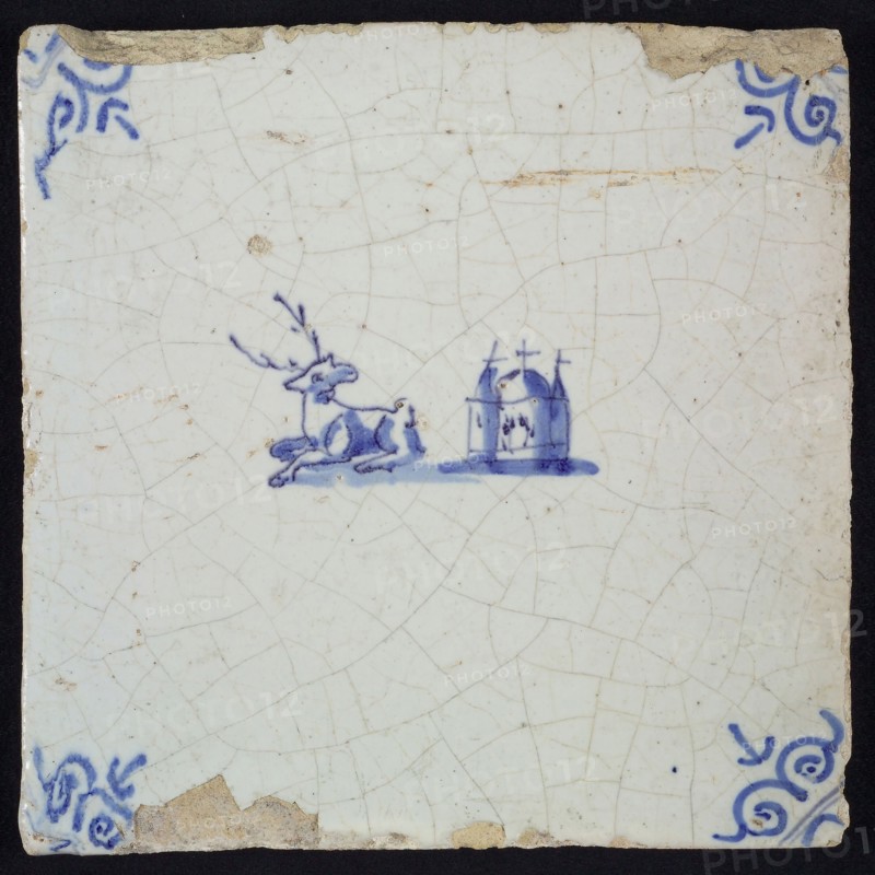 Animal tile, lying deer to the left and right next to it church, in blue on white, corner motif oxen head, wall tile