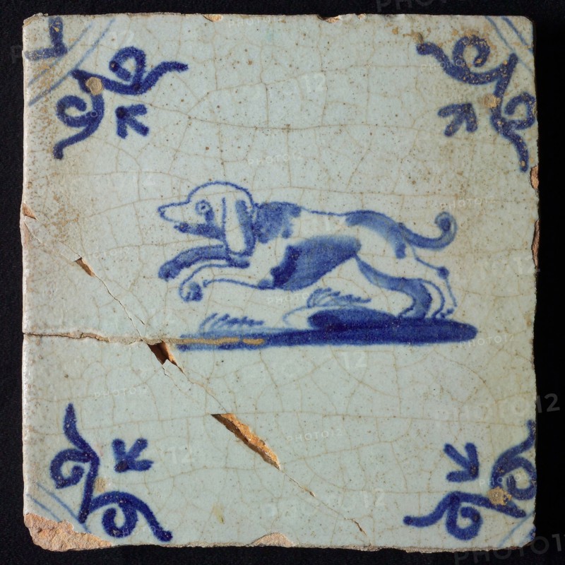 Animal tile, jumping dog to the left on ground, in blue on white, corner motif oxen head, wall tile tile sculpture ceramic