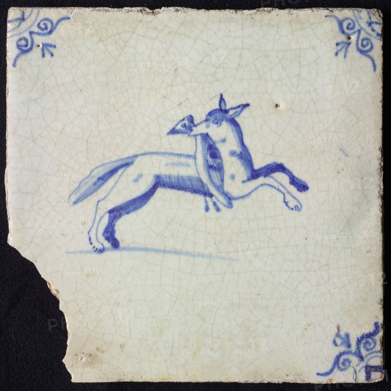 Animal tile, jumping fox to the right with bird in the mouth, in blue on white, corner pattern ox head, wall tile tile sculpture