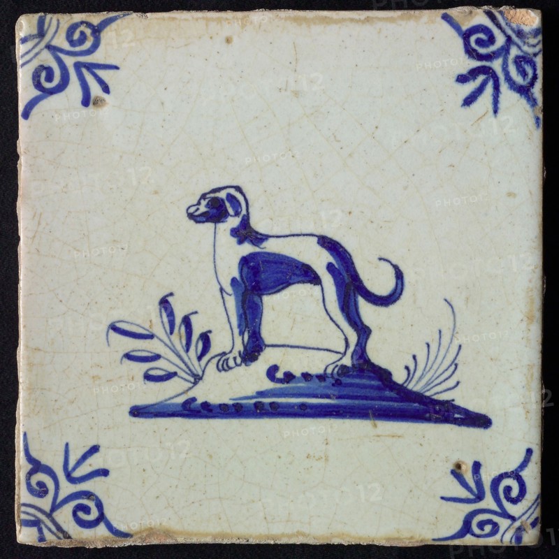 Animal tile, standing dog to the left on ground, in blue on white, corner motif oxen head, wall tile tile sculpture ceramic