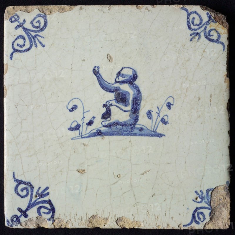 Animal tile, sitting monkey to the left on plot, in blue on white, corner patterned ox head, wall tile tile sculpture ceramic