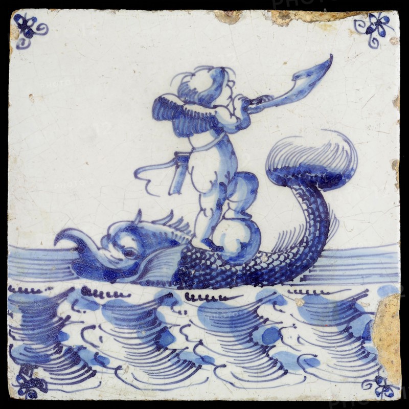 Scene tile, winged Cupid with one foot on globe and horn blowing, corner motif spider, wall tile tile sculpture ceramic