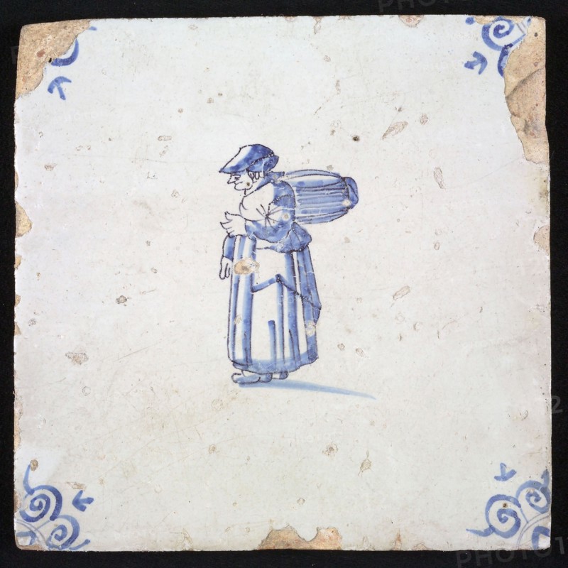 Figure tile, blue with woman with package or barrel on the back, corner motif ox's head, wall tile tile sculpture ceramic