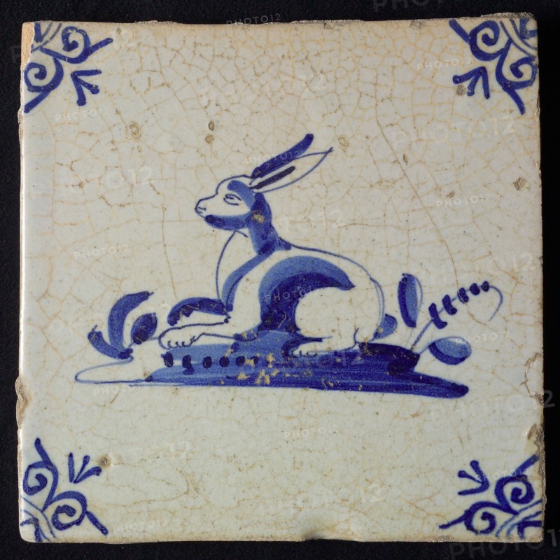 Animal tile, lying hare left on ground, in blue on white, corner pattern ox head, wall tile tile sculpture ceramic earthenware