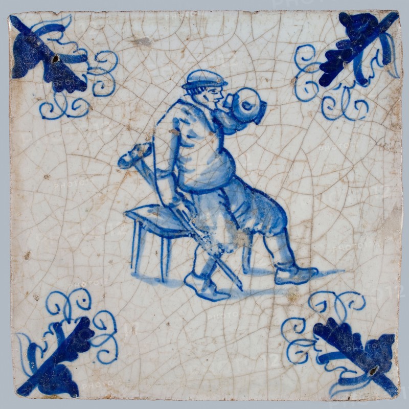 Figure tile, blue with man sitting on bench, stool in hand, drinking from crucible, corner motif, wall tile tile sculpture
