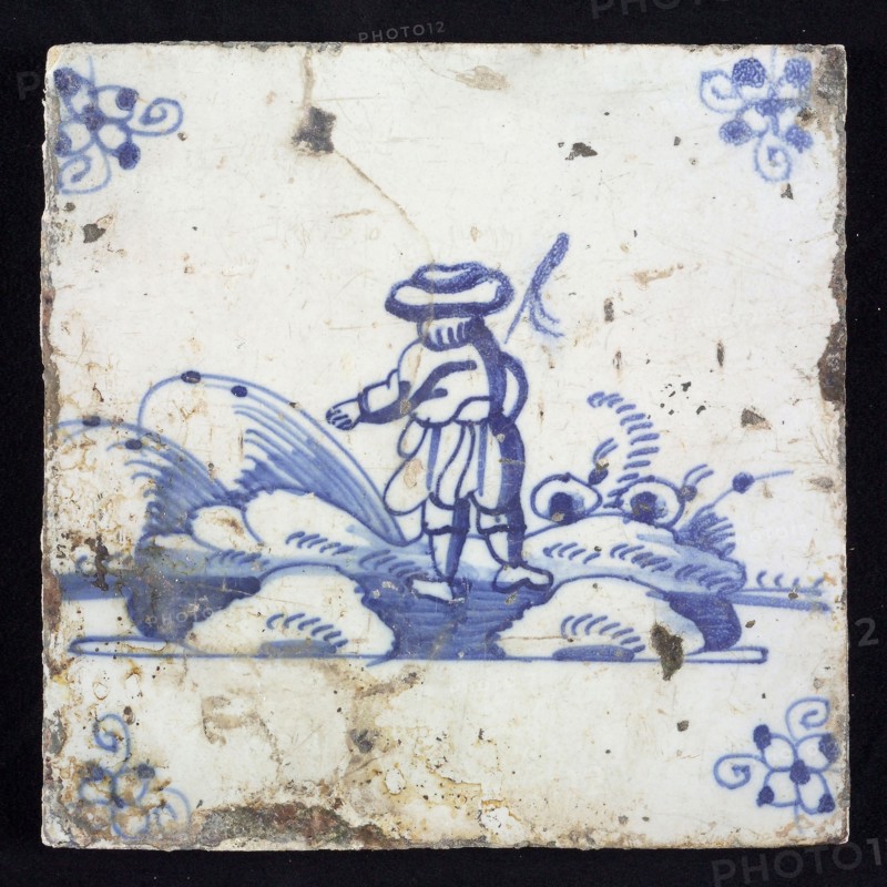 Figure tile, blue with landscape with standing shepherd seen on the back, corner pattern spider, wall tile tile sculpture