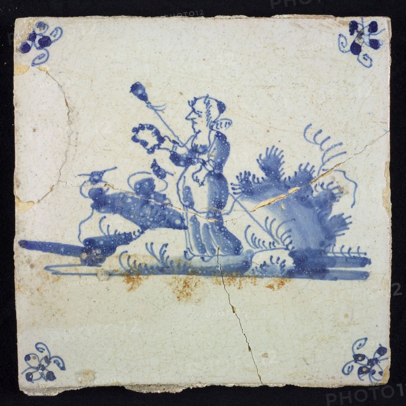 Figure tile, blue with landscape with standing shepherdess with garland and staff, corner motif spider, wall tile tile sculpture