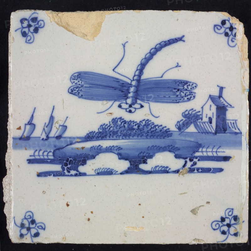 Animal tile, flying dragonfly above continuous ground, buildings with tower and three sailing ships in the background, in blue