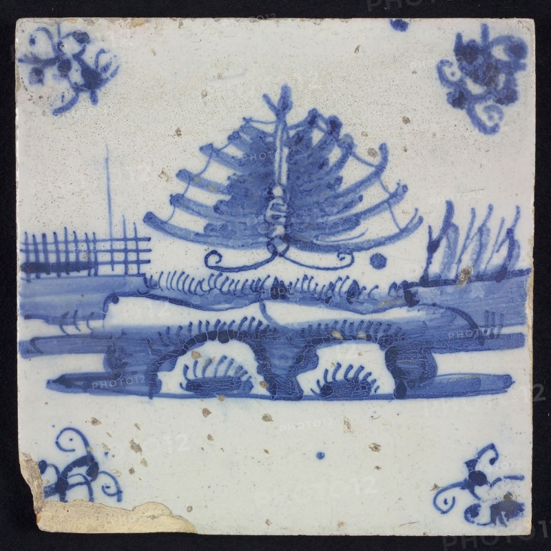 Animal tile, flying butterfly above continuous ground, right three sailing ships in the background, in blue on white, corner