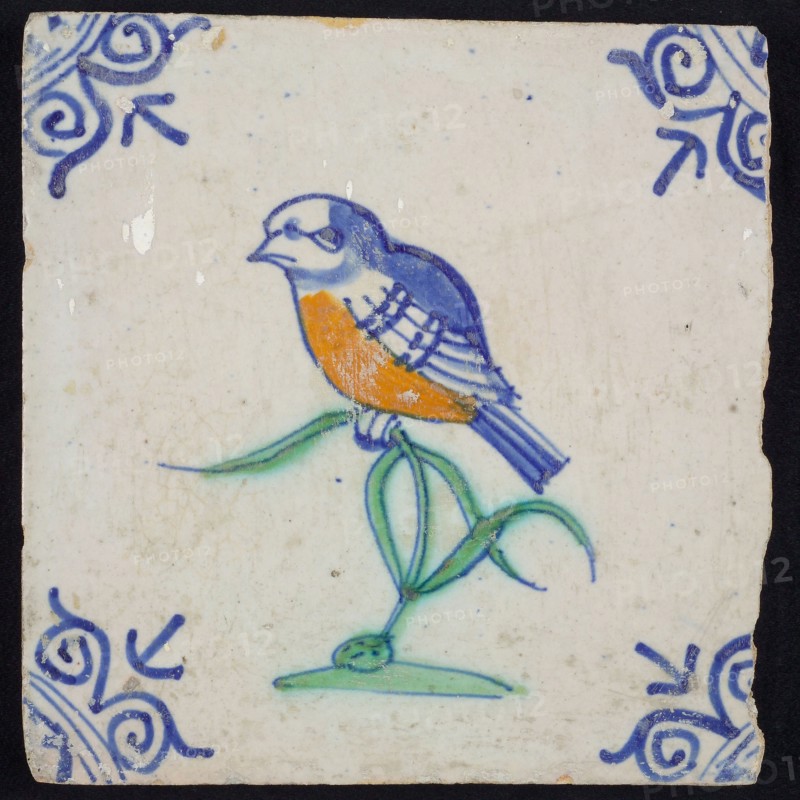 Animal tile, bird on plant to the left in orange, green and blue on white, corner pattern ossenkop, wall tile tile sculpture
