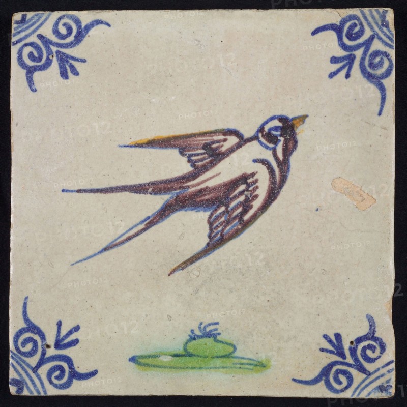 Animal tile, flying bird to the right above ground in orange, purple, green and blue on white, corner pattern ox head, wall tile