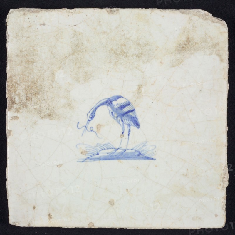 Animal tile, bird on plot with long fish in its beak to the left, blue on white, no corner pattern, wall tile tile sculpture