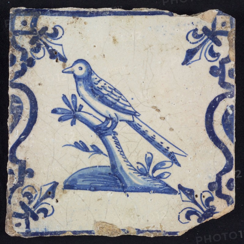 Animal tile, bird on branch on plot to the left between balusters in blue on white, corner pattern french lily, wall tile