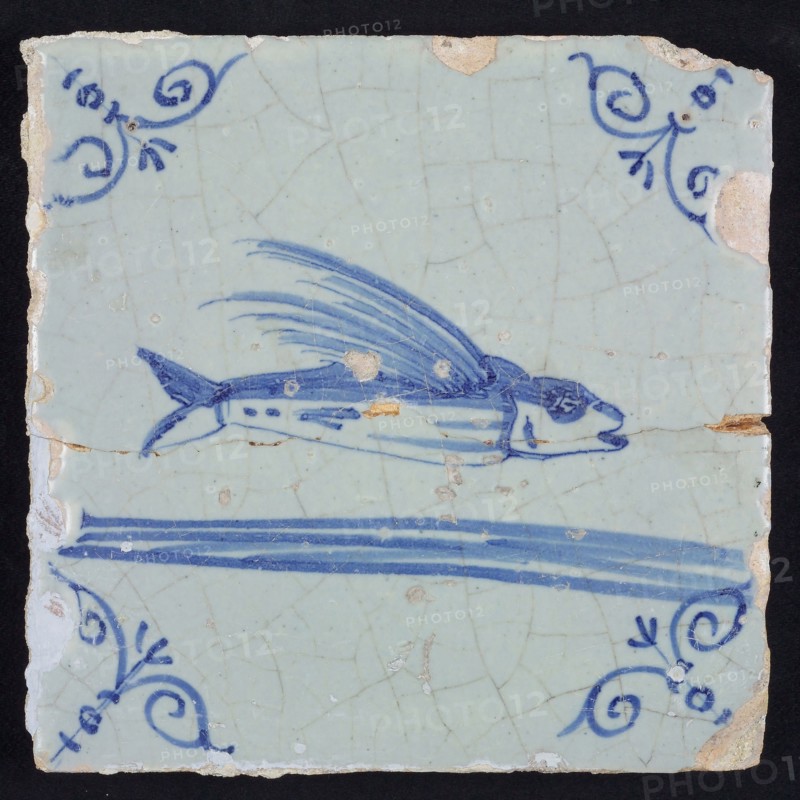 Animal tile, flying fish above running water to the right, in blue on white, corner patterned ox head, wall tile tile sculpture