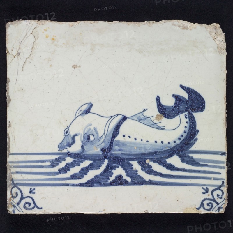 Animal tile, sea-washed in continuous water to the left, in blue on white, corner motif of ox-head, wall tile tile sculpture