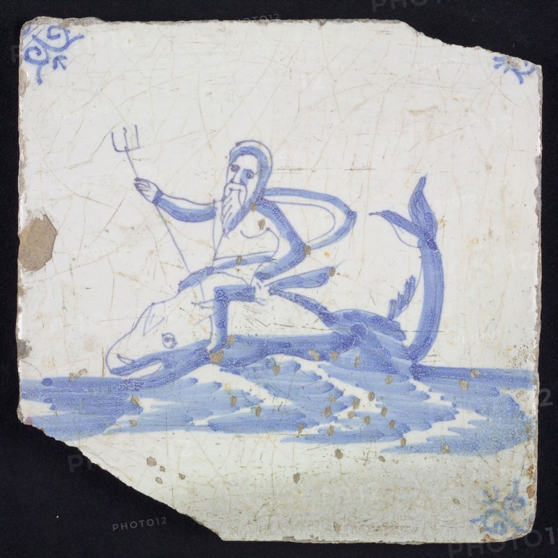 Sea Pewter, man with trident sitting on dolphin in running water to the left, in blue on white, corner motif oxen head, wall