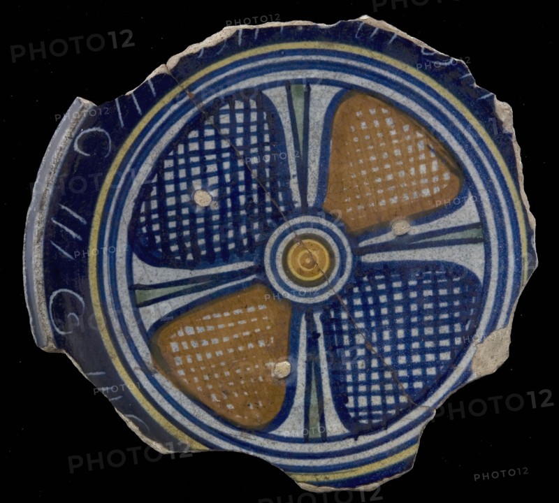 Fragment majolica dish, yellow, orange, green and blue on white, decor with four-lobed floral pattern with orange and blue